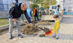 Küçük çocuk oyuncak el arabası ile belediye işçilerine yardım etti