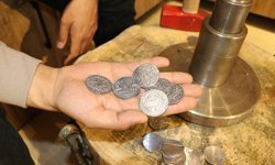Hediyelik eşya dükkanında isteyenlere eski dönemlere ait sikke bastırıyor